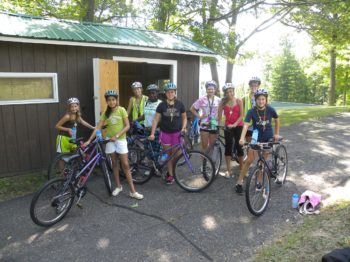 Campers getting ready to go on a bike ride.