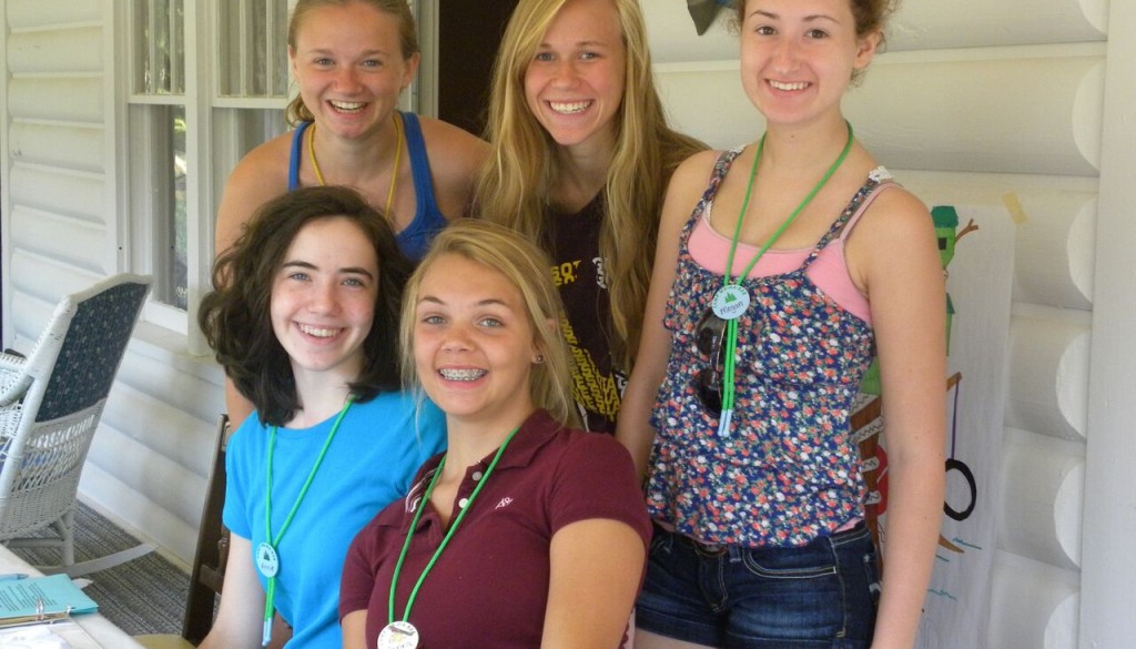 girls smiling in front of cabin