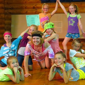 Campers and counselor showing off a dance routine