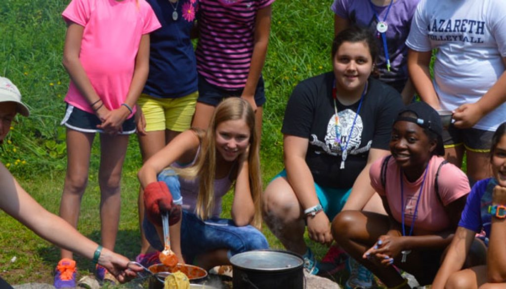 Learning how to cook over a fire at WeHaKee Camp for Girls