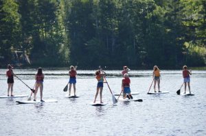 WeHaKee Camp for Girls paddle boarding on Lake Hunter.