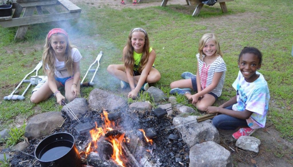 Campers making pudgy pies in the fire at WeHaKee Camp for Girls.