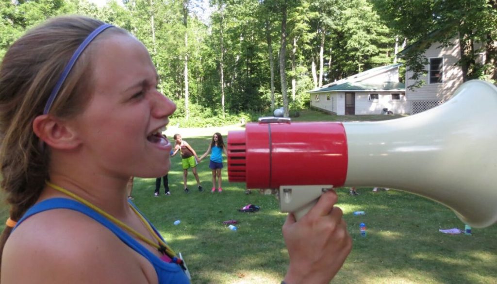 Thatch, camper at WeHaKee Camp for Girls, yelling into a megaphone.