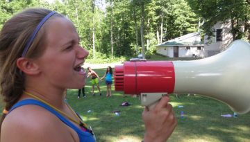 Thatch, camper at WeHaKee Camp for Girls, yelling into a megaphone.