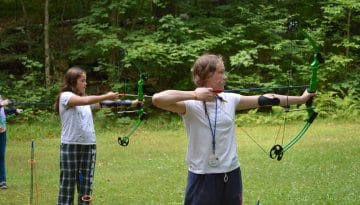 Campers practicing shooting bow and arrow and WeHaKee Camp for Girls.