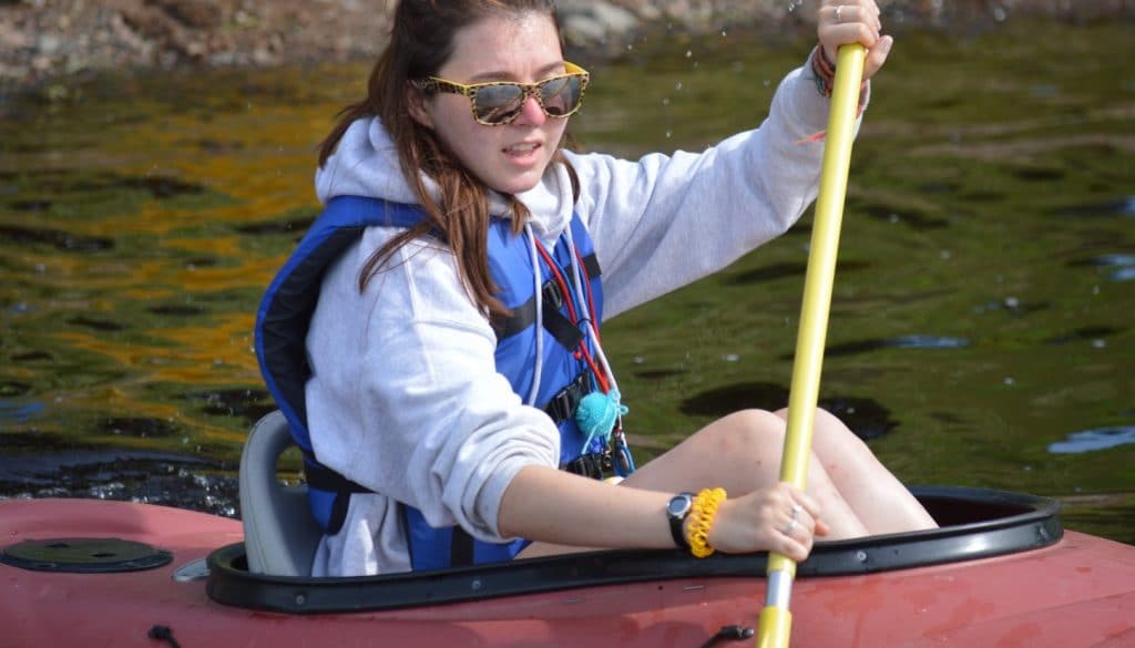 WeHaKee Camp for Girls camper paddling in a kayak.