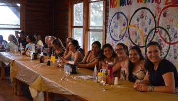 WeHaKee Camp for Girls campers sitting at the WeHaKee Olympics table.