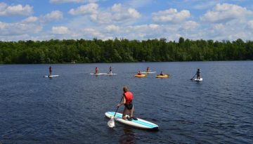 WeHaKee Camp for Girls campers paddleboarding and kayaking.