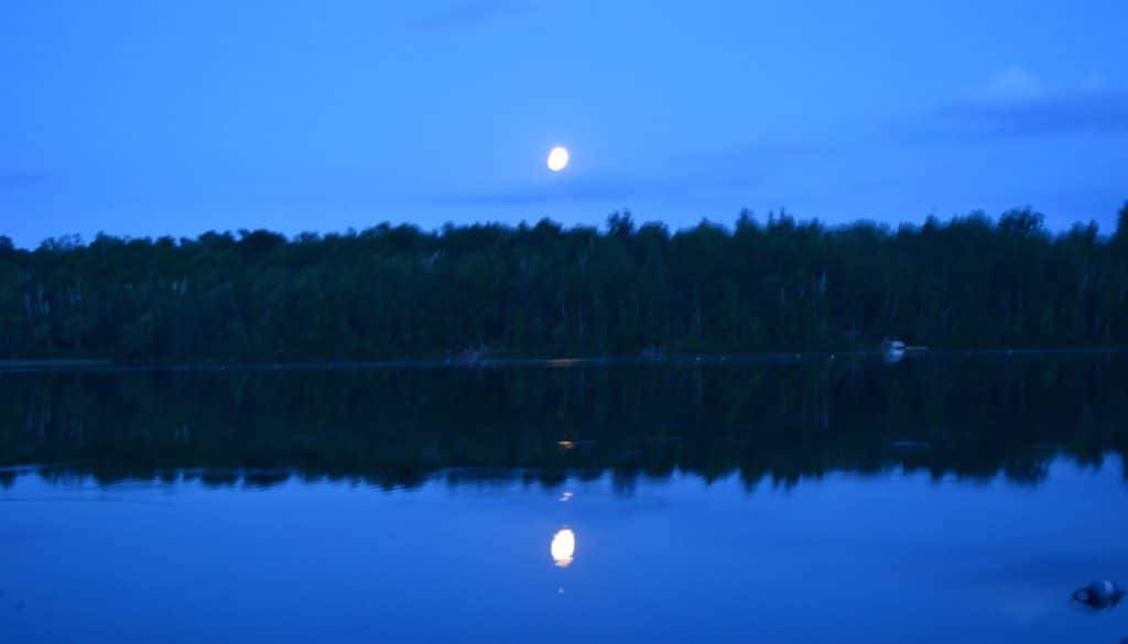 Moon above the trees across Hunter Lake.