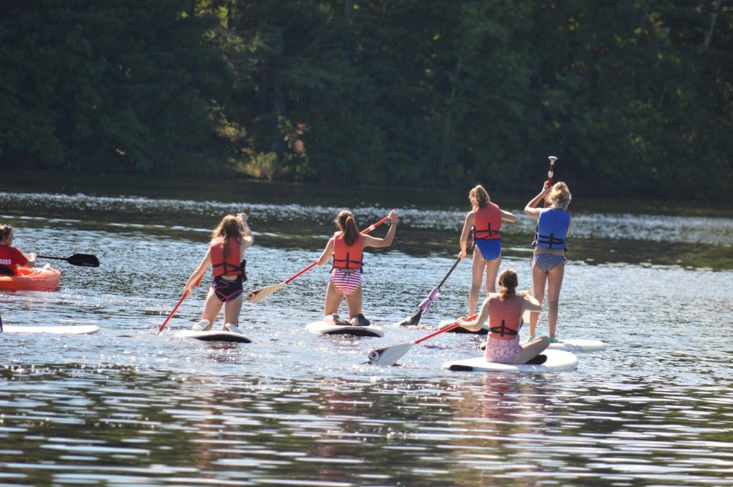 WeHaKee Camp for Girls Campers paddle boarding on Hunter Lake during water activities.