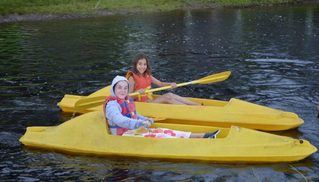 Two WeHaKee campers having fun on the lake in their yellow kayaks