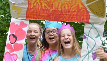 WeHaKee Camp for Girls Campers being silly with a cardboard frame.