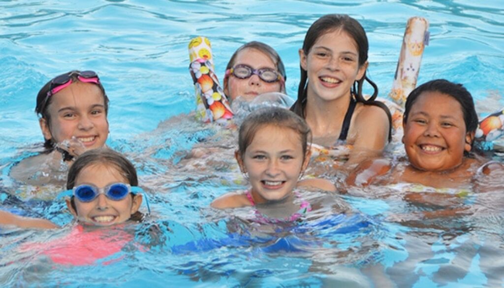 WeHaKee Camp for Girls Campers swimming with floaties.