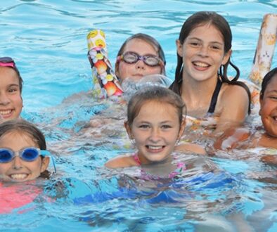 WeHaKee Camp for Girls Campers swimming with floaties.