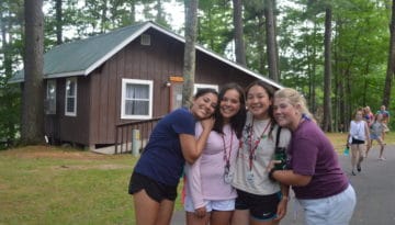 WeHakee Camp for Girls staff group photo in front of cabin.