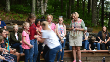 WeHaKee Camp for Girls staff giving the campers pins on their badges.