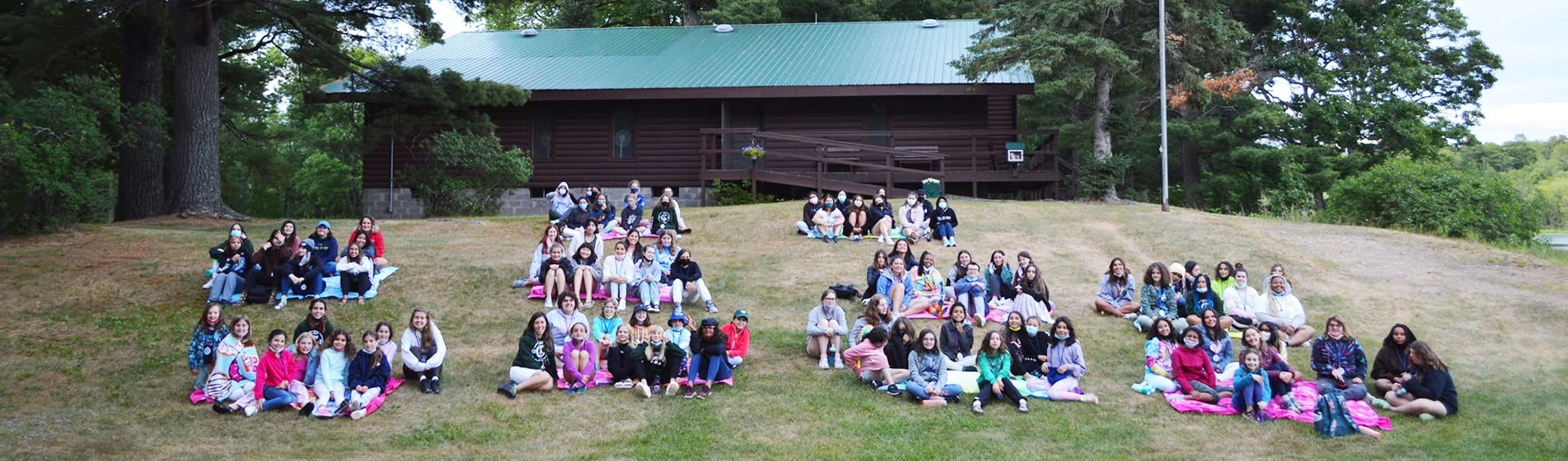 Groups of campers sitting on the hill at WeHaKee Camp for Girls in Wisconsin.