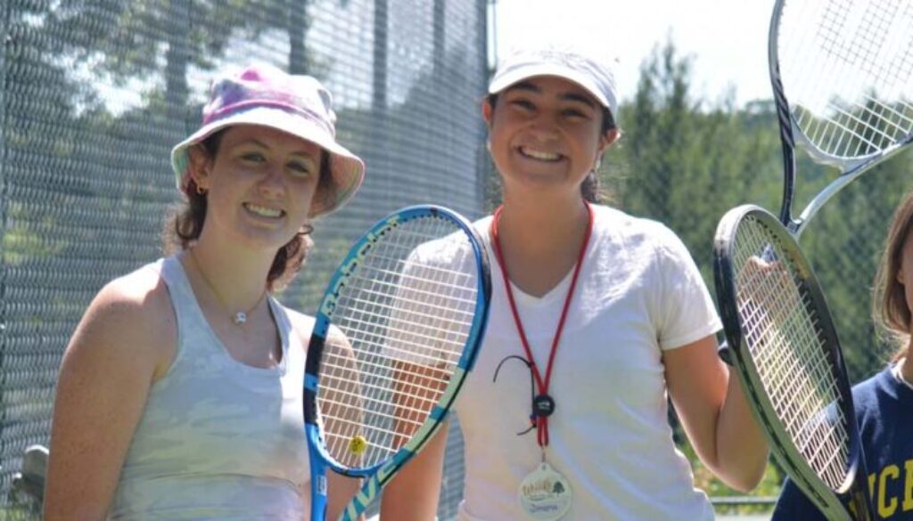 WeHaKee Camp for Girls counselor and three campers holding tennis rackets.