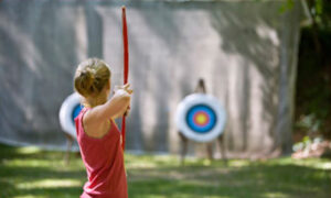 A camper using a bow at the archery grounds at WeHaKee Camp For Girls