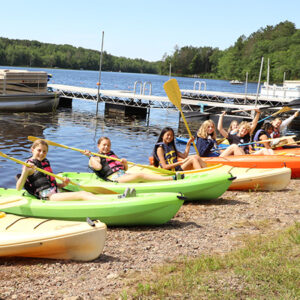 WeHakee campers sitting in Kayaks (Funyaks) on the shore of Hunter lake.